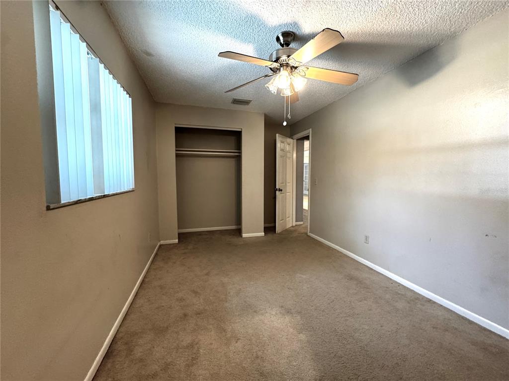 3419 Pearson Road Valrico, FL 33596 - Photo 7 of 20 an empty room with chandelier fan and windows