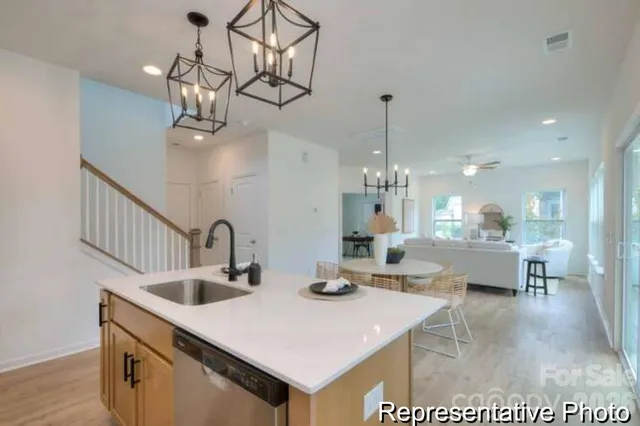 a kitchen with kitchen island granite countertop a sink a counter top appliances and cabinets