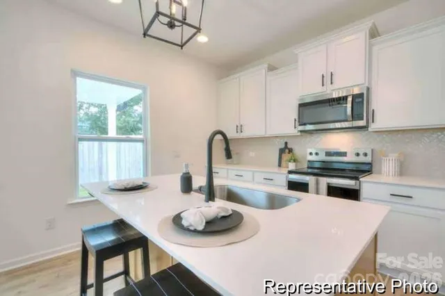 a kitchen with stainless steel appliances a stove a sink and a microwave