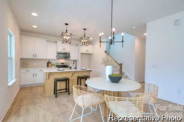a dining room with kitchen island a chandelier and a dining table