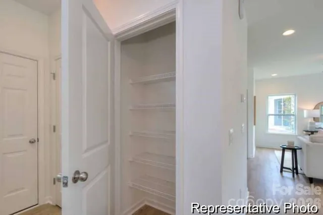a view of a hallway with windows and a cabinet