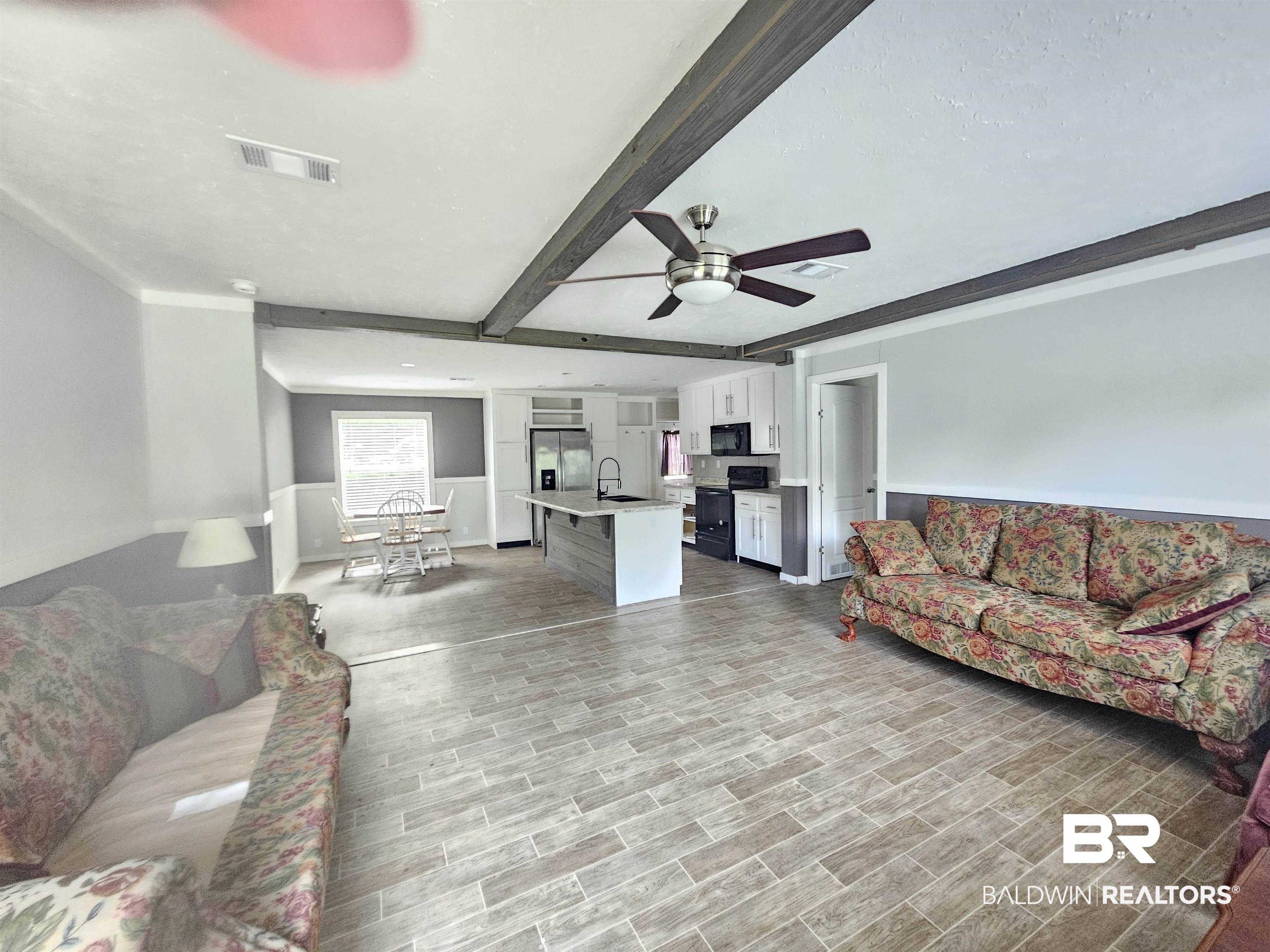 1863 Wait Road Monroeville, AL 36460 - Photo 6 of 38 Living room featuring sink, light hardwood / wood-style flooring, ceiling fan, and beam ceiling