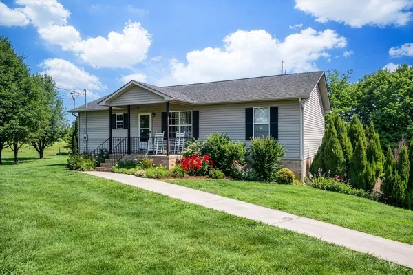 a front view of a house with a garden and yard