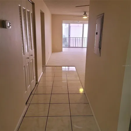 an empty room with a ceiling fan and a large window