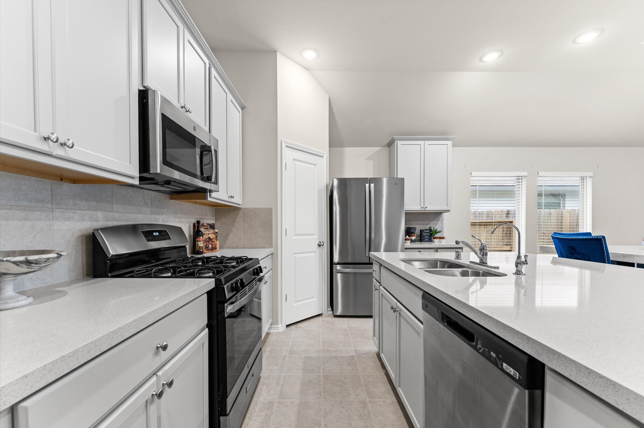 2702 Meadow View Lane Conroe, TX 77385 - Photo 16 of 26 a kitchen with stainless steel appliances granite countertop a sink stove microwave and refrigerator