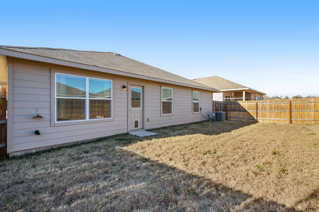 3609 Batson Drive Austin, TX 78725 - Photo 21 of 33 Rear view of property with a fenced backyard and a shingled roof