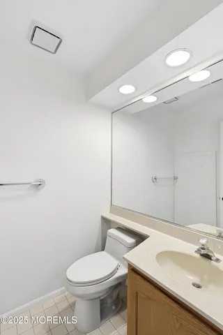 a bathroom with a sink mirror vanity and toilet