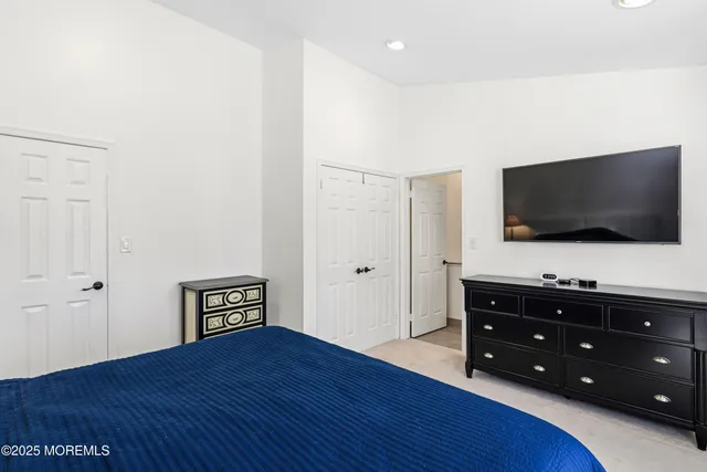 a living room with flat screen tv on dresser and a wooden floor