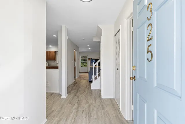 a view of a hallway with wooden floor and staircase