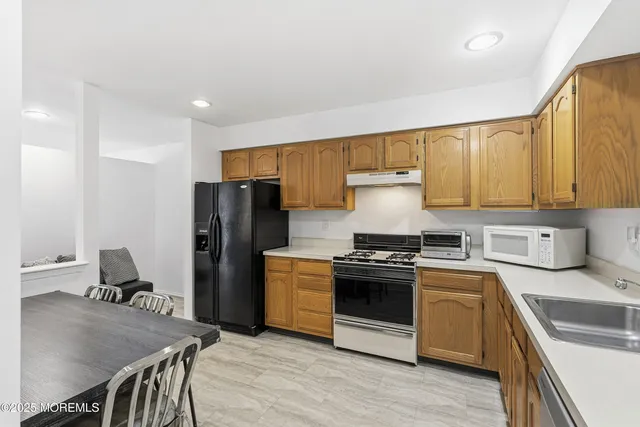 a kitchen with a stove a sink and a refrigerator