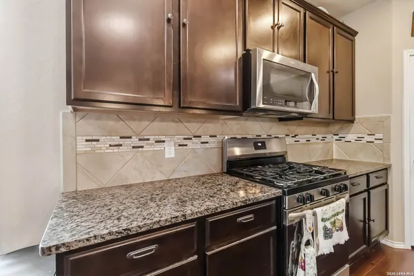 a kitchen with stainless steel appliances granite countertop a sink stove and microwave