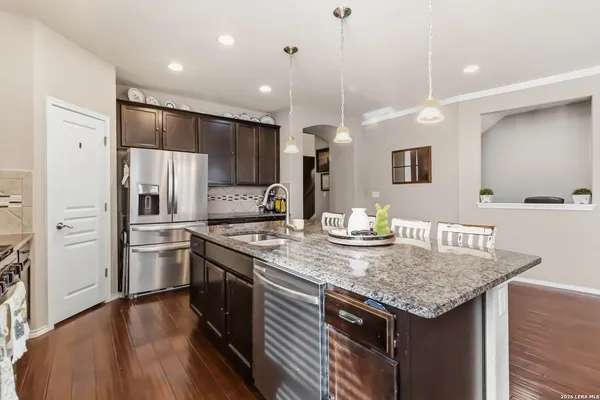 a kitchen with stainless steel appliances granite countertop a sink a stove and refrigerator