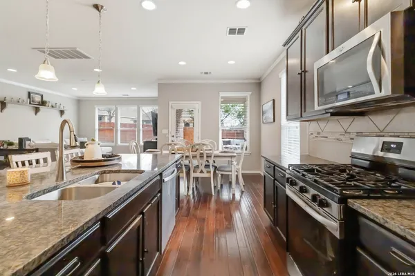 a kitchen with stainless steel appliances granite countertop a lot of counter space and wooden floors