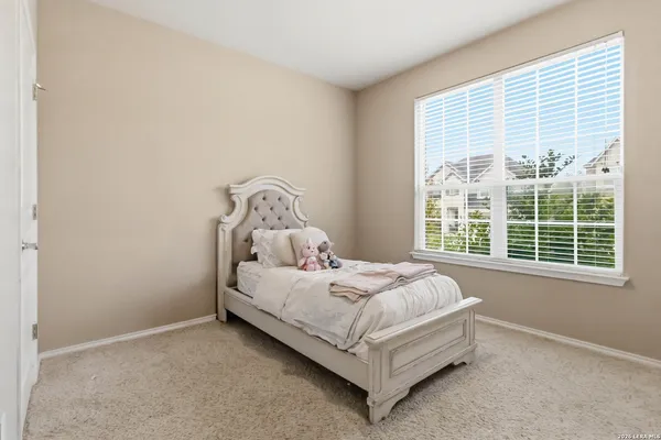 a bed sitting in a bedroom next to a window