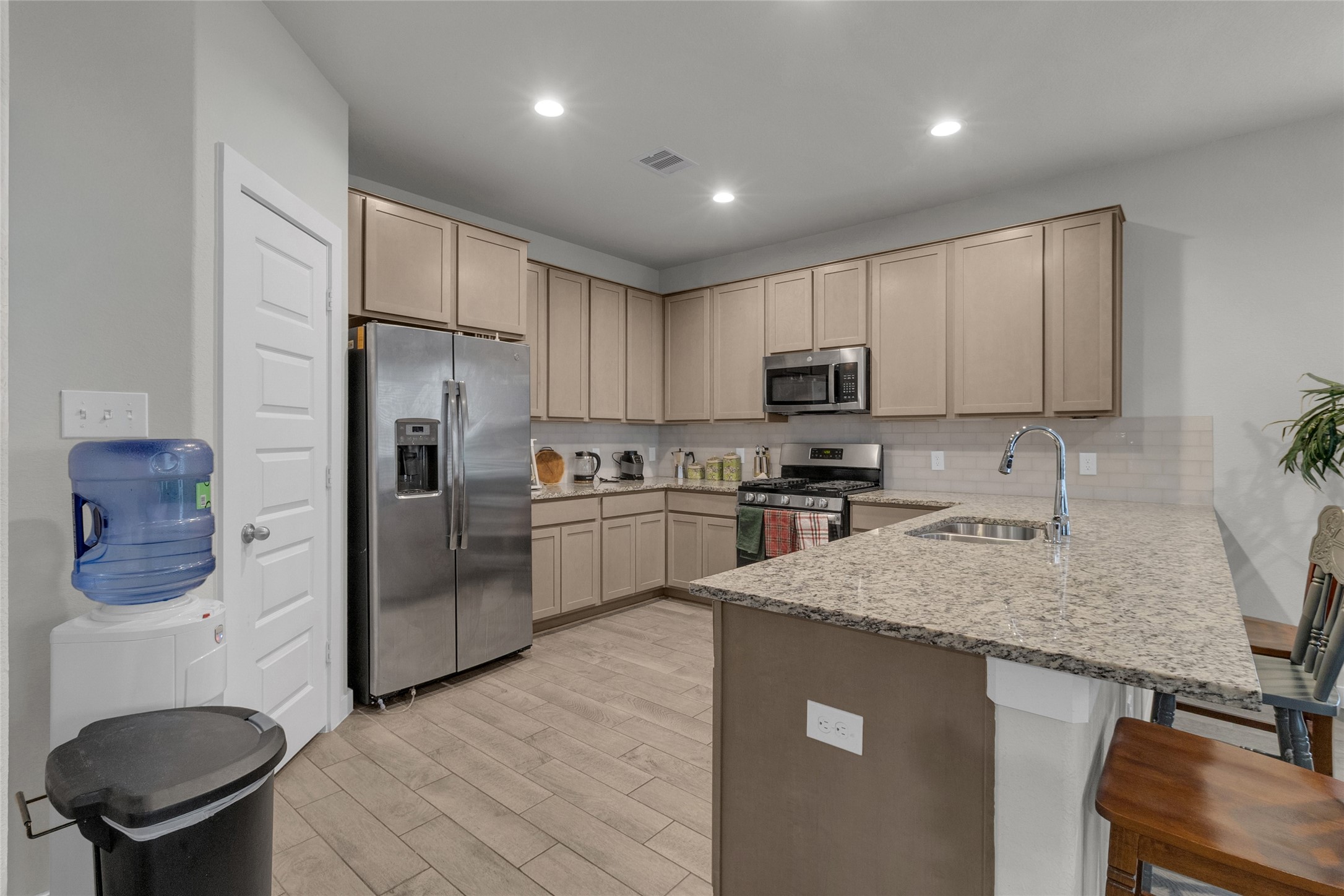 2314 Village Side Trail Rosenberg, TX 77471 - Photo 8 of 31 a kitchen with a sink a microwave a refrigerator and cabinets
