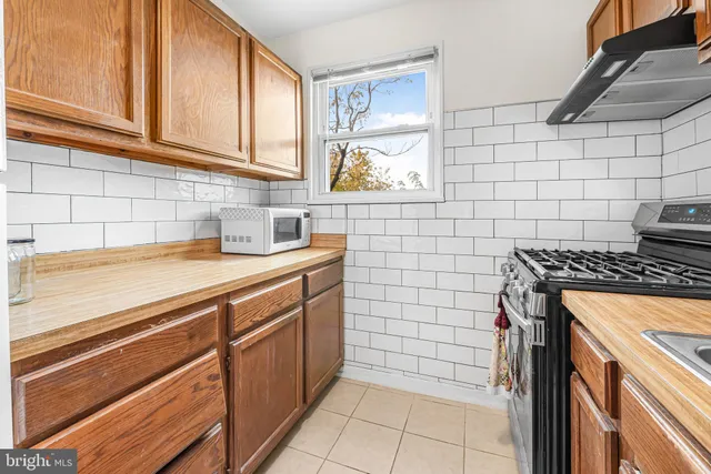 an empty room with wooden floor ceiling fan and windows