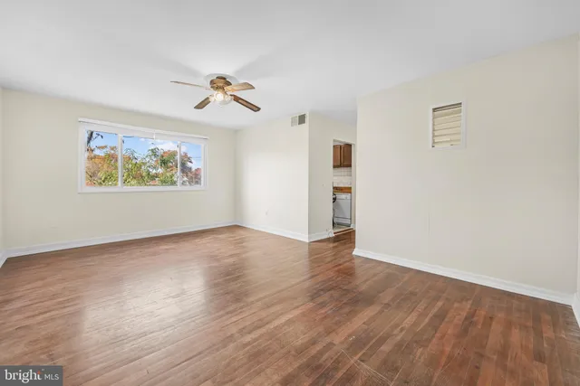 a view of empty room with wooden floor