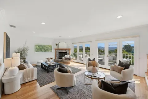 a living room with furniture fireplace and a large window