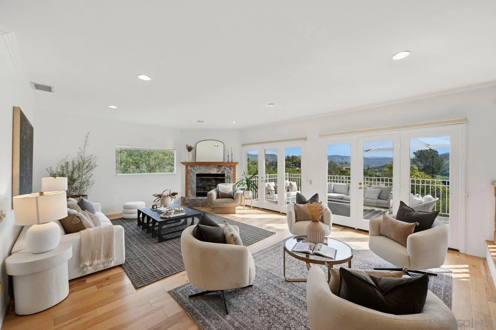 a living room with furniture fireplace and a large window