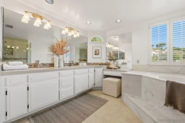 a spacious en suite bathroom with a double vanity sink and a mirror