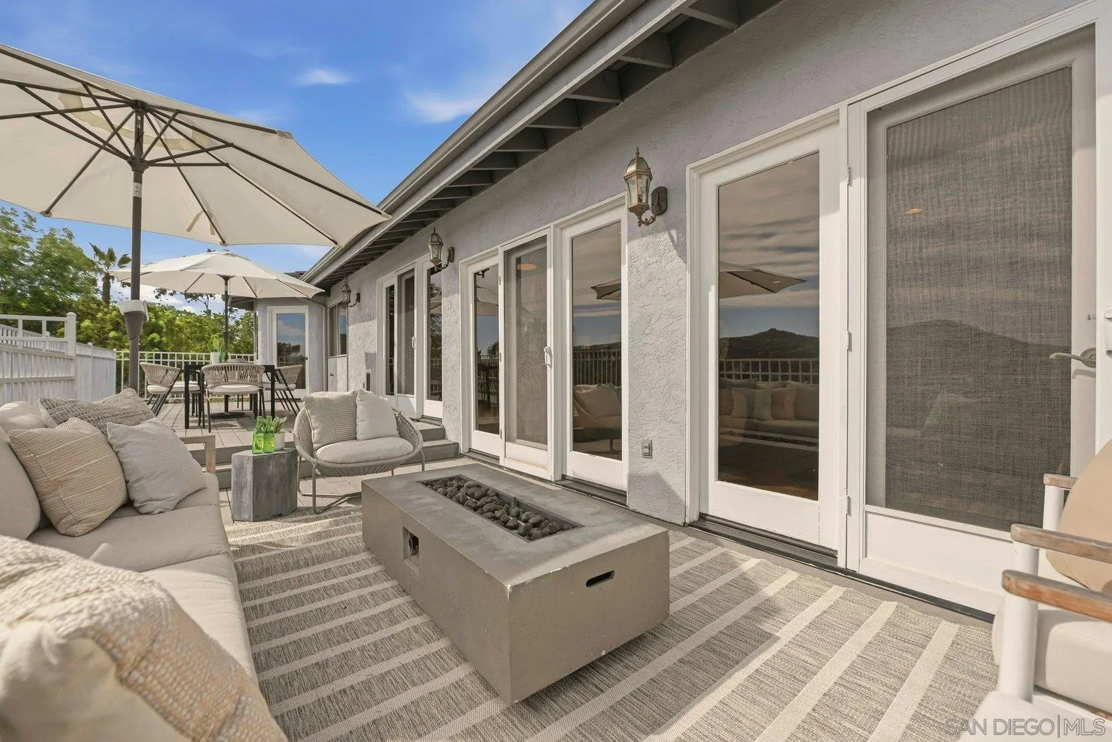 3132 Don Rolando Escondido, CA 92025 - Photo 35 of 56 a view of a patio with couches and table and chairs under an umbrella