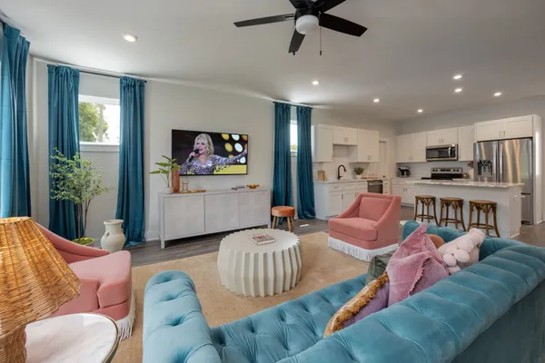 a living room with furniture kitchen view and a large window