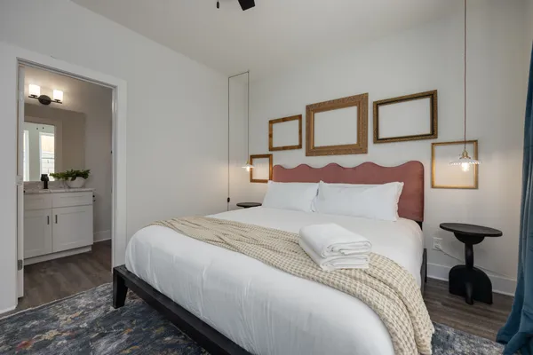 a bedroom with a bed and a lamp on dresser