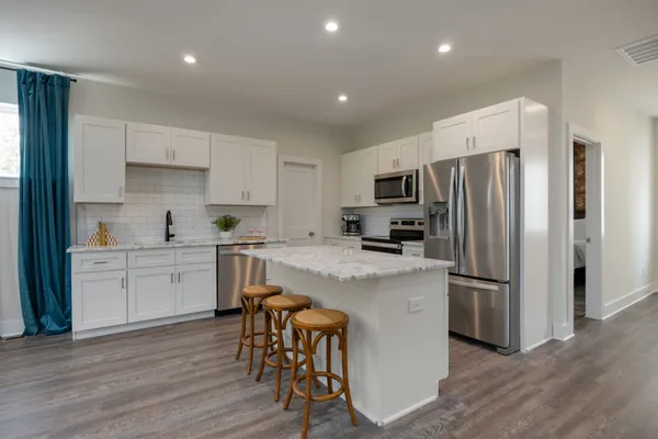a kitchen with stainless steel appliances a refrigerator stove microwave and cabinets