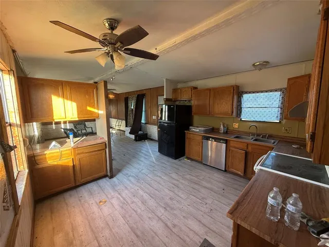 a kitchen with stainless steel appliances kitchen island granite countertop a stove and a wooden floors