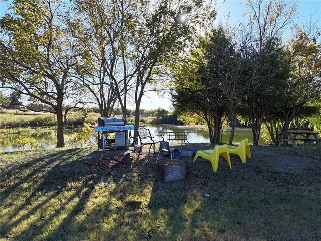 a view of a backyard with table and chairs and a large tree