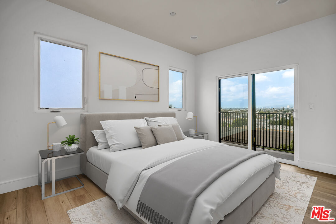 4703 Saturn Street Los Angeles, CA 90019 - Photo 12 of 37 a bedroom with a balcony a bed and a chandelier