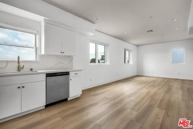 a kitchen with granite countertop white cabinets and white appliances
