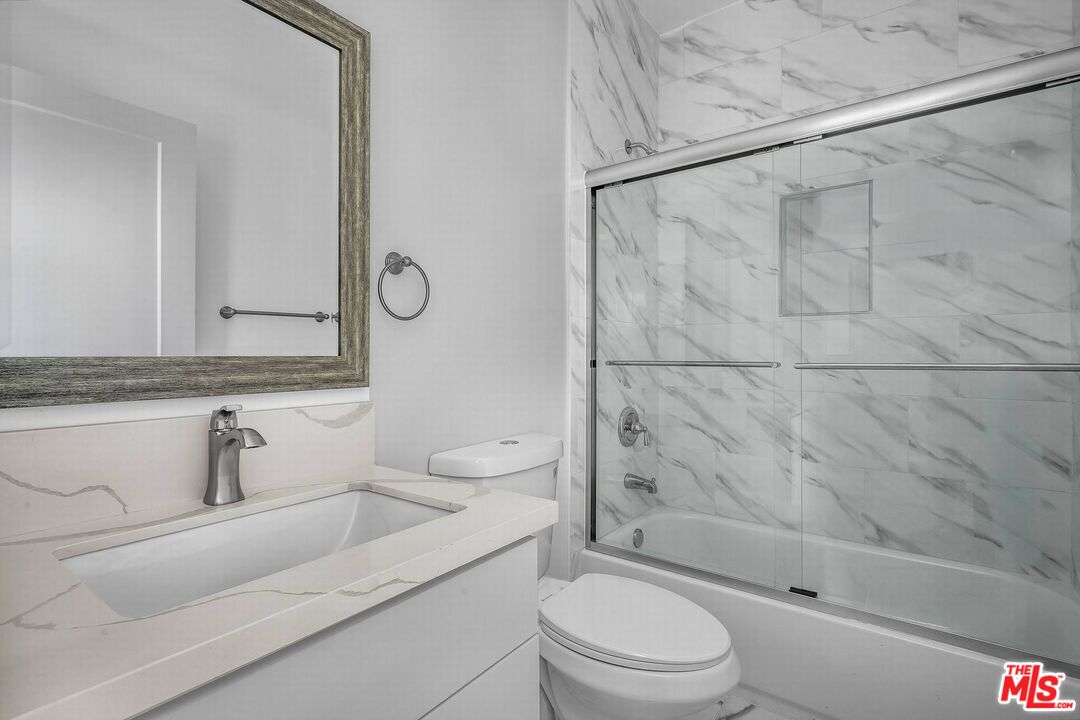 4703 Saturn Street Los Angeles, CA 90019 - Photo 18 of 37 a bathroom with a toilet sink vanity and shower