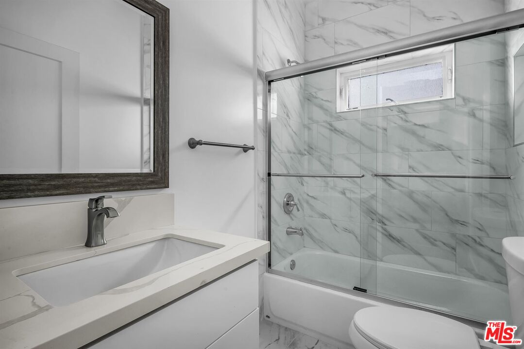 4703 Saturn Street Los Angeles, CA 90019 - Photo 19 of 37 a bathroom with a sink a toilet and shower