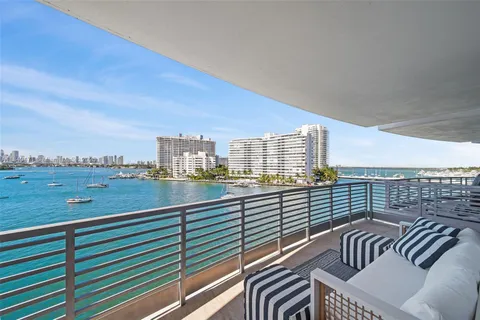 a living room with stainless steel appliances kitchen island granite countertop a refrigerator and a cabinets