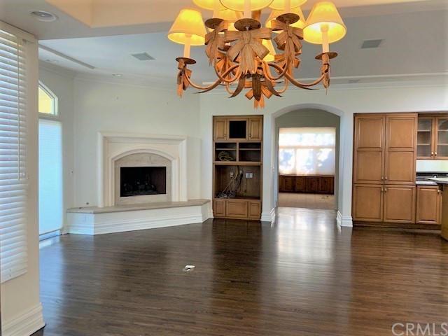 3930 Coral Place Calabasas, CA 91302 - Photo 15 of 50 a view of a room with wooden floor a fireplace a chandelier and windows