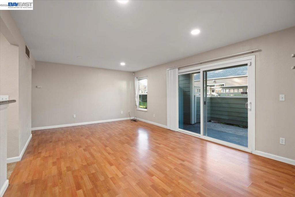 215 Reflections Drive San Ramon, CA 94583 - Photo 3 of 17 a view of an empty room with wooden floor and a window