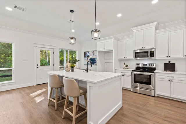 a view of a hallway with wooden floor and windows