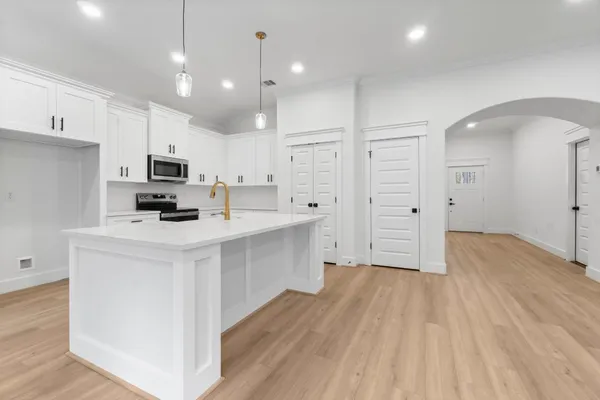 a kitchen with kitchen island a sink stainless steel appliances and cabinets