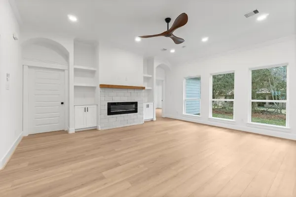 a view of an empty room with a fireplace and a window