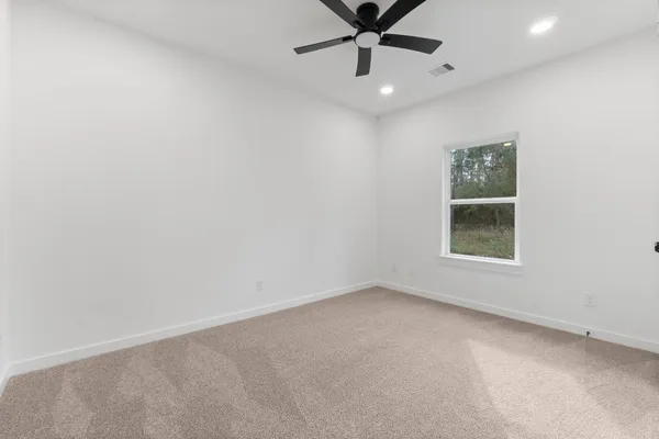 an empty room with a window and a fan
