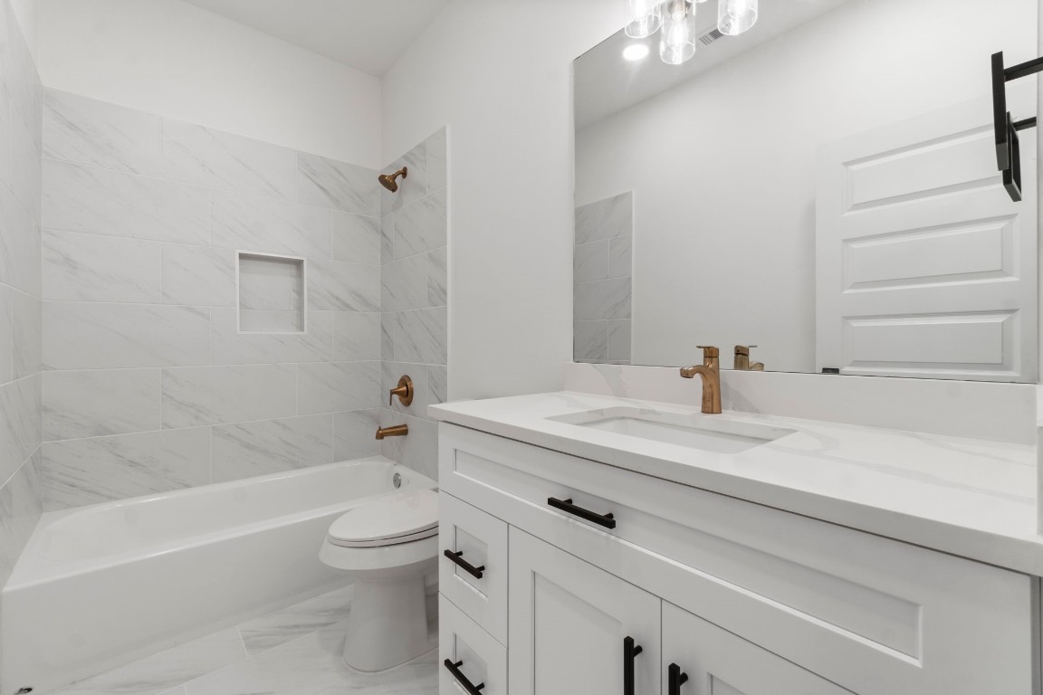 34 Cottonwood Trinity, TX 75862 - Photo 17 of 44 a bathroom with a granite countertop toilet a sink and a bathtub