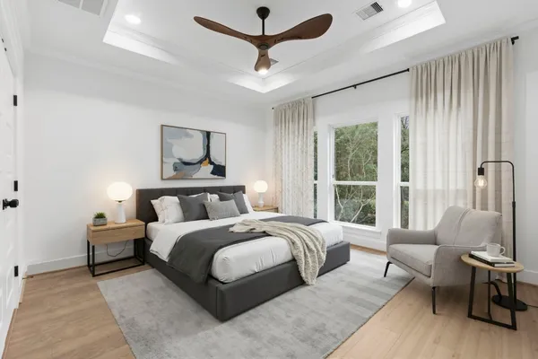 a bedroom with a bed couch and a large window