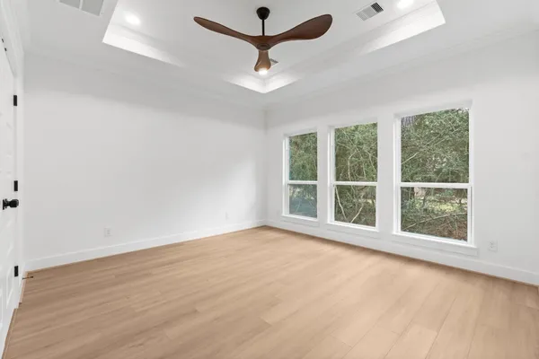 an empty room with a window and a ceiling fan