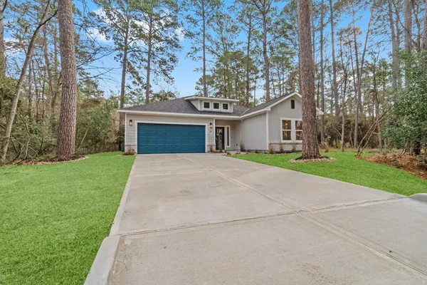 front view of a house with a yard and an trees