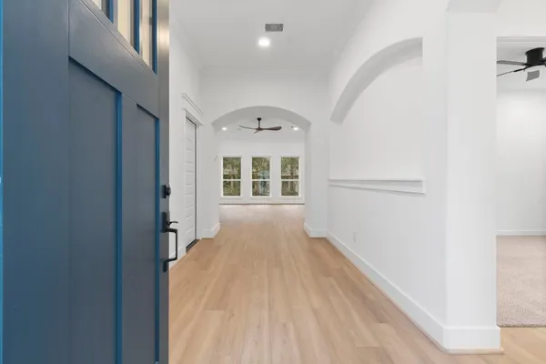 a view of a hallway with wooden floor and a window