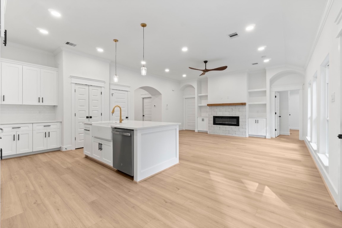 34 Cottonwood Trinity, TX 75862 - Photo 10 of 44 a large white kitchen with a sink a fireplace and a refrigerator