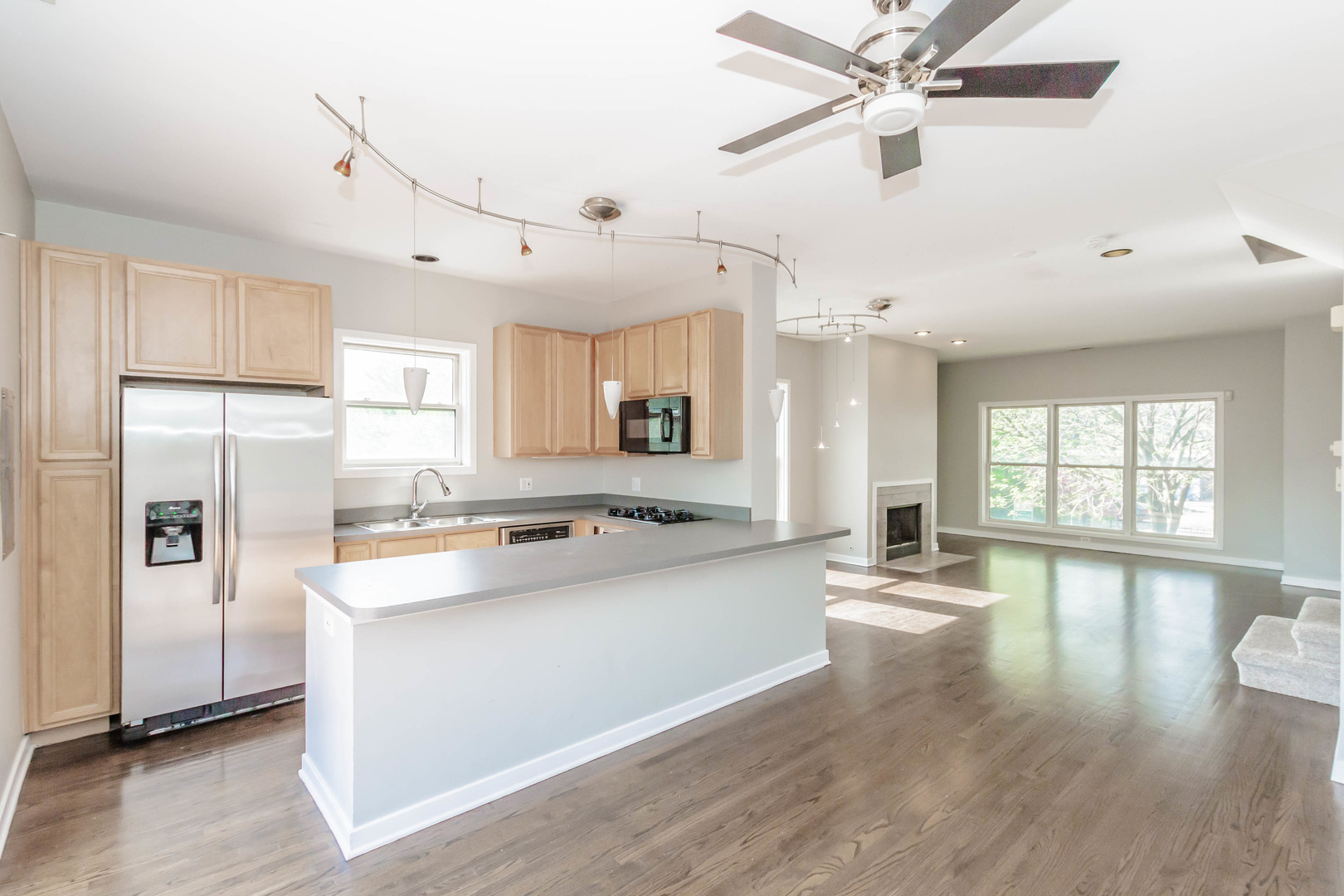 1443 West Fillmore Street Chicago, IL 60607 - Photo 19 of 37 a large kitchen with kitchen island a large counter space a sink appliances and a window