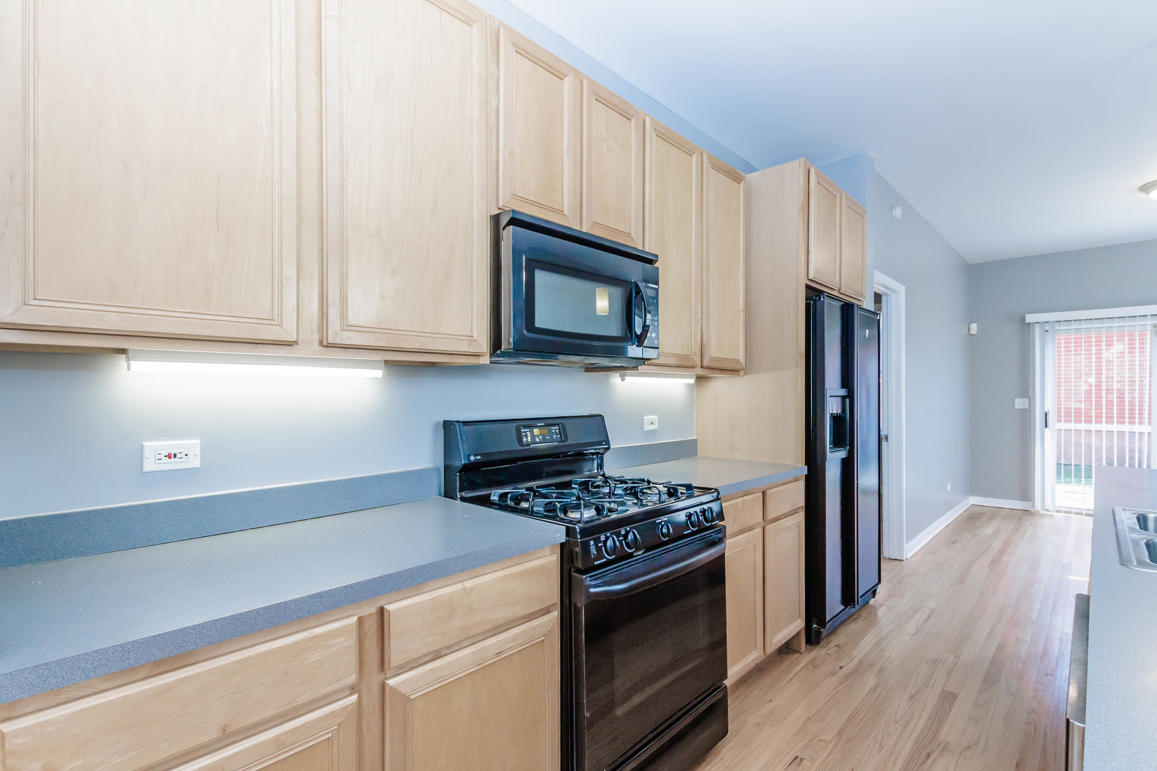 1443 West Fillmore Street Chicago, IL 60607 - Photo 8 of 37 a kitchen with stainless steel appliances granite countertop a stove a refrigerator and a microwave