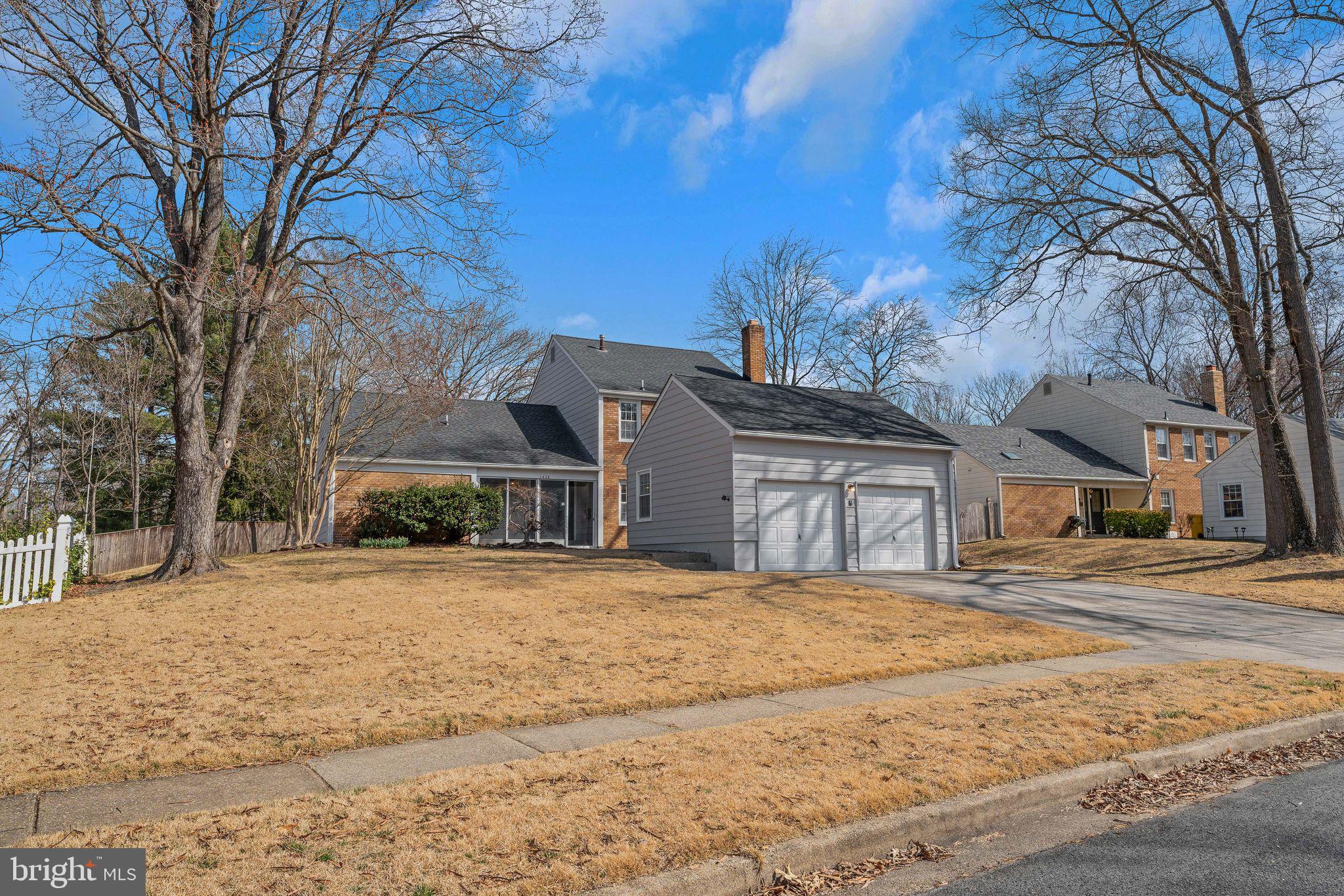 a front view of house with yard covered with trees